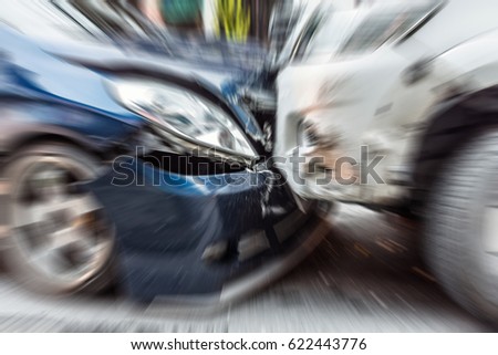 Blurred zoom of Car crash from car accident on the road in a city between saloon versus pickup wait insurance.