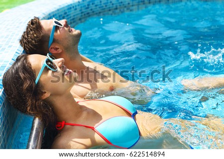 Young couple are relaxing in swimming pool. Summer vacation concept