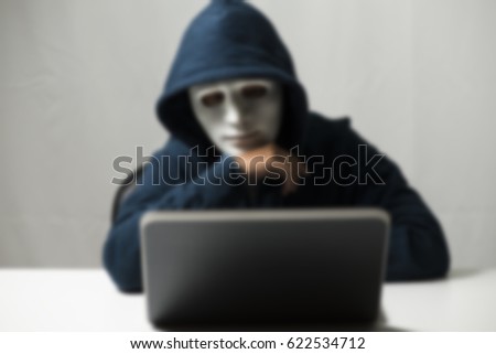 Hacker in a mask blur.Terrorist working on his computer. Concept about terrorist and bandit