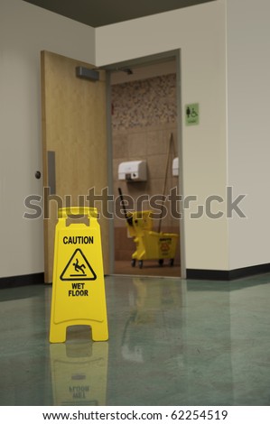 A Caution Sign warns people of a wet floor in front of the women's restroom