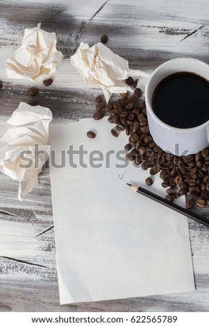 a sheet of paper for recording ideas on wooden background and coffee