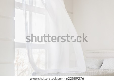 Abstract white waving curtain in white bedroom apartment Royalty-Free Stock Photo #622589276
