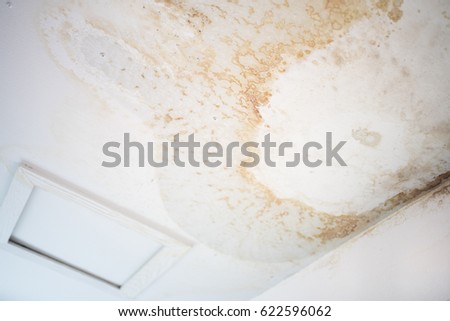 Peeling paint on an interior ceiling a result of water damage caused by a leaking pipe a result of substandard plumbing completed by an unqualified plumber. A common house insurance claim Royalty-Free Stock Photo #622596062
