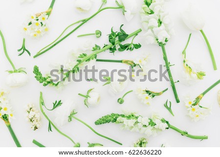 Floral pattern made of white ranunculus, snapdragon and tulip on white background. Flat lay, top view. Background of flowers