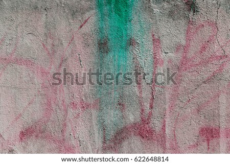 Multicolored paint stains on city walls. The painted spots of graffiti tag. Traces of painted hooligan graffiti. Abstract background tag, street art on old city walls and fences