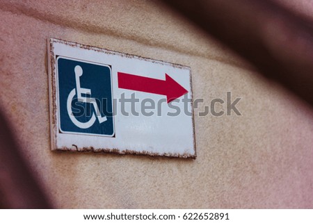 Signpost with a red arrow for the disabled