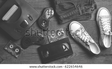 Back in the 90s. Shoes, audio tapes, video tapes, game console, jeans. Top view. Flat lat. Royalty-Free Stock Photo #622654646