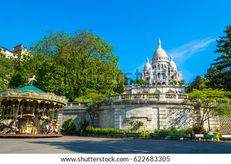 Sacre Coeur Basilica in Paris at day with blue bright sky and green grass. 
