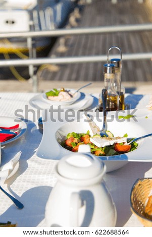 Greek salad or Fresh tasty vegetable salad with white feta cheese on the table in Restaurant on a beach.