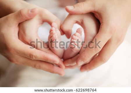 Baby feet heart: baby's feet in mom's and dad's hands Royalty-Free Stock Photo #622698764