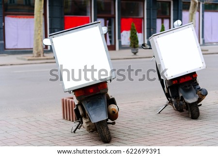 Mopeds parked on the roadside, rear view. Moped service delivery. Pack sign with copy space. Mock-up service delivery. Royalty-Free Stock Photo #622699391