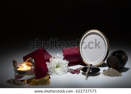 black urn with red tape,white chrysanthemum, rosary for sympathy card on background
