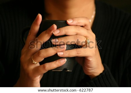 Woman holding a cup of tea/coffee/soup. Image has a shallow DOF and focus is on the fingernails. A warm tone has been given to set the mood.