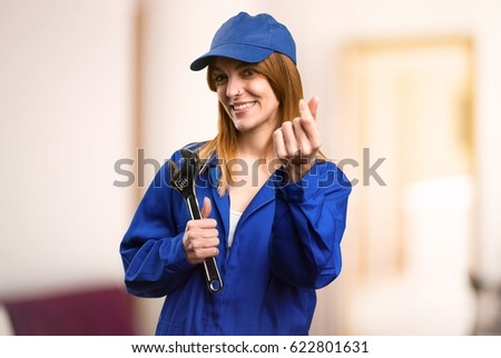 Delivery woman making money gesture on defocused background