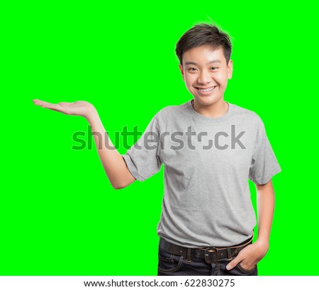 Young man display your product or message concept background. Handsome young man multiracial asian / caucasian model Isolated on green screen chroma key background.