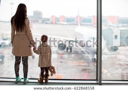 Mother and little girl in airport waiting for boarding