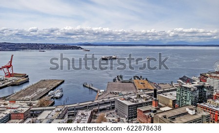 Aerial view of Seattle waterfront district and Elliott Bay. Looking east to west, you see the shoreline, bay, and business and  industrial district.