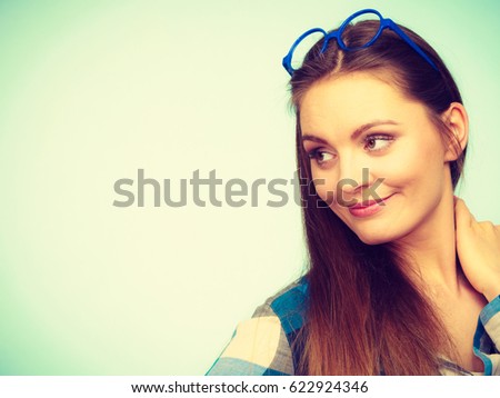 Studying, beauty of education and fun concept. Attractive nerdy woman in weird big glasses on head. Studio shot on blue background