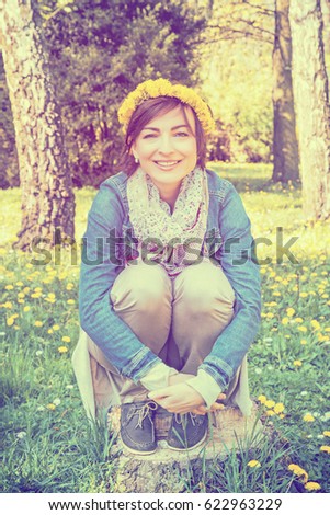 Young romantic woman with wreath of dandelions in the park. Natural beauty. Rainbow vintage photo filter. Spring time.