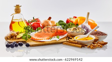 Panoramic banner with fresh healthy food for the heart and cardiovascular system with nuts, herbs, salmon, spices, bell peppers, tomatoes, broccoli, garlic, olive oil and blueberries on white Royalty-Free Stock Photo #622969142