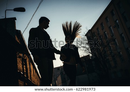 Amazing silhouette of lovers. True love emotions of joyful cute couple enjoying time together outdoor in city. Lovely happy moments, having fun, smiling in love on the background of the city. Good.