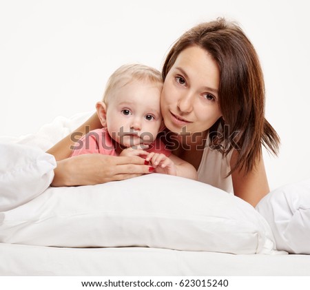 Happy family mother and baby having fun on bed
