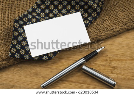 Pen and business card over the wooden board.