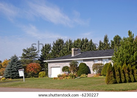 A house in the suburbs with a sold sign on the front lawn.
