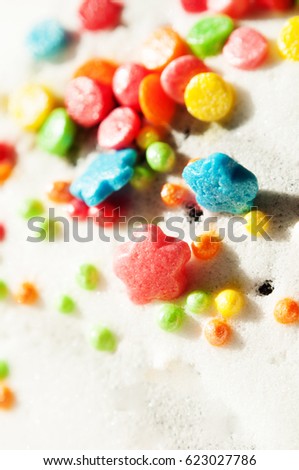 Abstract background. Macro photography. Multi colored sprinkling for Easter cakes on white glaze. Place for the text. Selective sharpness, soft focus. Shooting in daylight