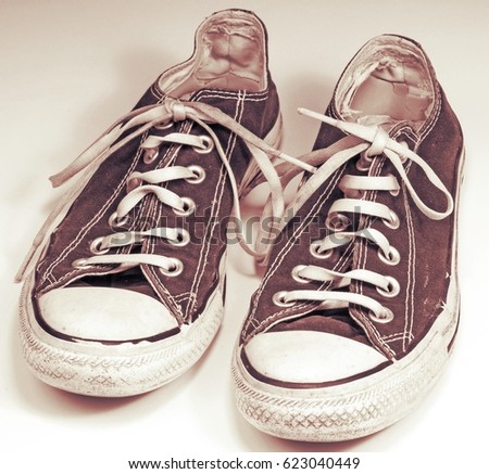 A pair of dirty sneakers on top retro textured background