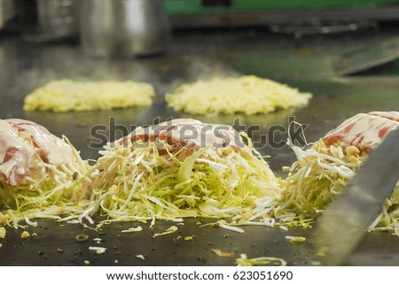 The process of cooking okonomiyaki, traditional, Japanese food (hot plate japanese pizza or called pancake)