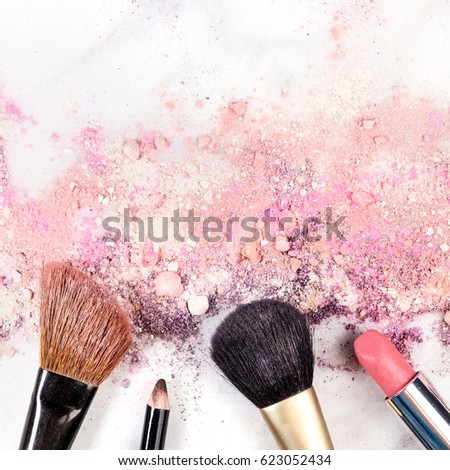Makeup brushes, lipstick and pencil on a white background, with traces of powder and blush on it. A square template for a makeup artist's business card or flyer design, with copy space