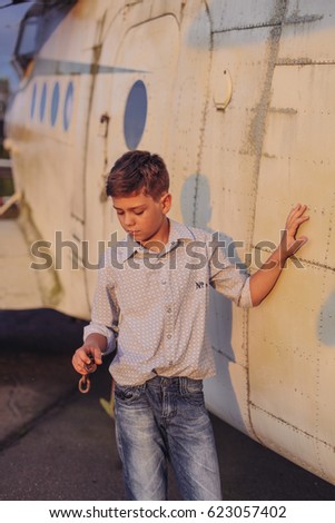 Kid, boy on an old little plane, summer, sunset