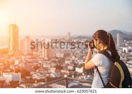 Young female photographer shooting the sunset.