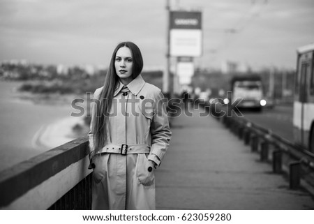 Beautiful woman on the bridge. Black and white picture with film grain imitation.