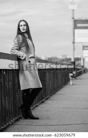 Beautiful woman on the bridge. Black and white picture with film grain imitation.