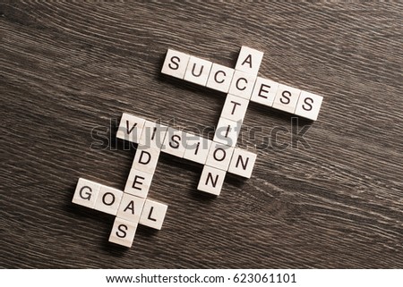 Success and other related words in crossword on wooden table
