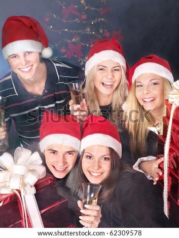 Group young people in santa hat drink champagne at nightclub.