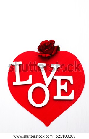 White love letter on red heart with red flower on white background