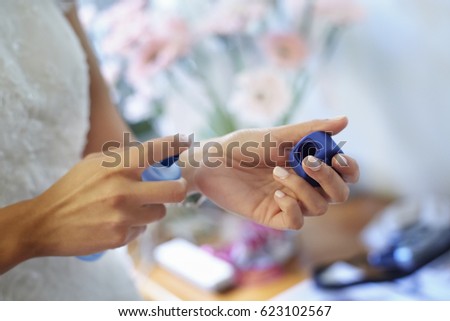 Woman hands spraying perfume on her wrist. Unrecognizable person. Horizontal format. Close up picture. 
