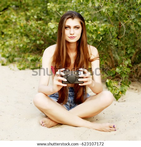 Young pretty woman taking a photography at the beach in summer