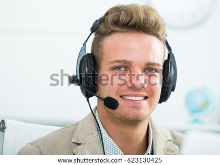 Portrait of young and successful call centre operator in office