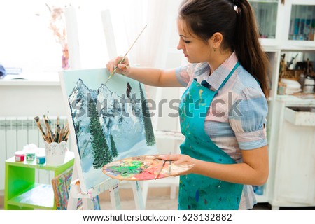 beautiful young girl draws a picture paints on art lesson