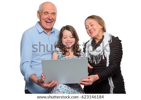 Horizontal photo of family enjoying internet jokes. Grandparents and their child using notebook and laughing at funny viral pictures.