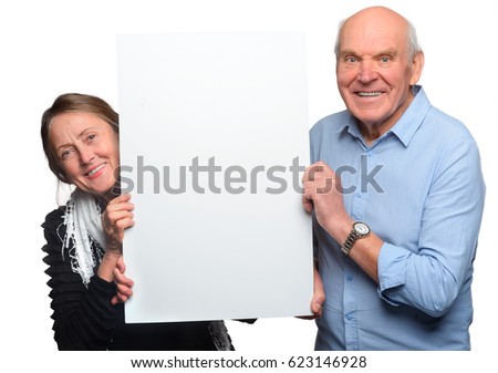 Horizontal pic of grandparents pose with empty placard on white background. Smiling pensioners hold a big white canvas for your text or picture.