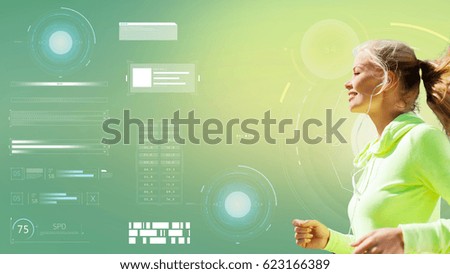 fitness, sport, people and technology concept - happy young woman with earphones running over green background