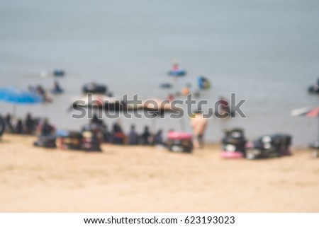 Blurred photograph of people playing sea water at the beach.