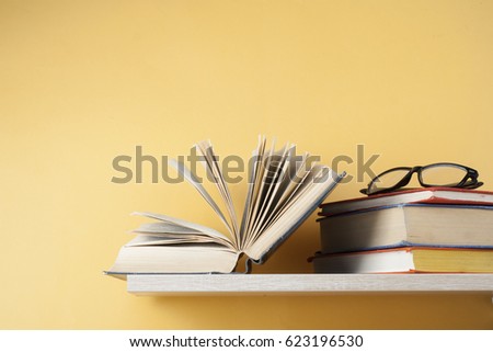 Open book, hardback books on wooden shelf. Back to school. Copy space for text. Education concept