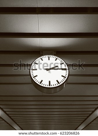 Big ancient vintage minimalism style clock hanging on the roof of Metro Train station in vintage color style, 