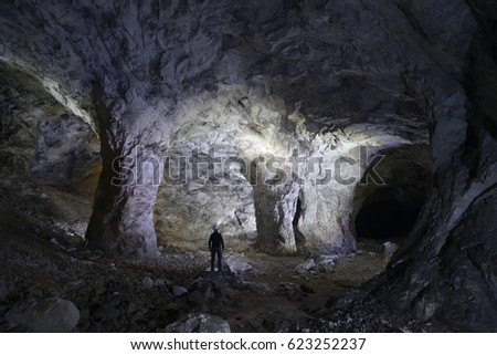 One Spelunker explore a beautiful cave with torch. Royalty-Free Stock Photo #623252237